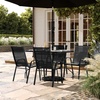 image:imageFlash Furniture Brazos Commercial Outdoor Dining Set 47 Tempered Glass Patio Table with Umbrella Hole 4 Stack Chairs with Flex Comfort Seats and Backs BlackBlackBlack